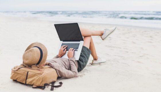 Young woman using laptop on a beach